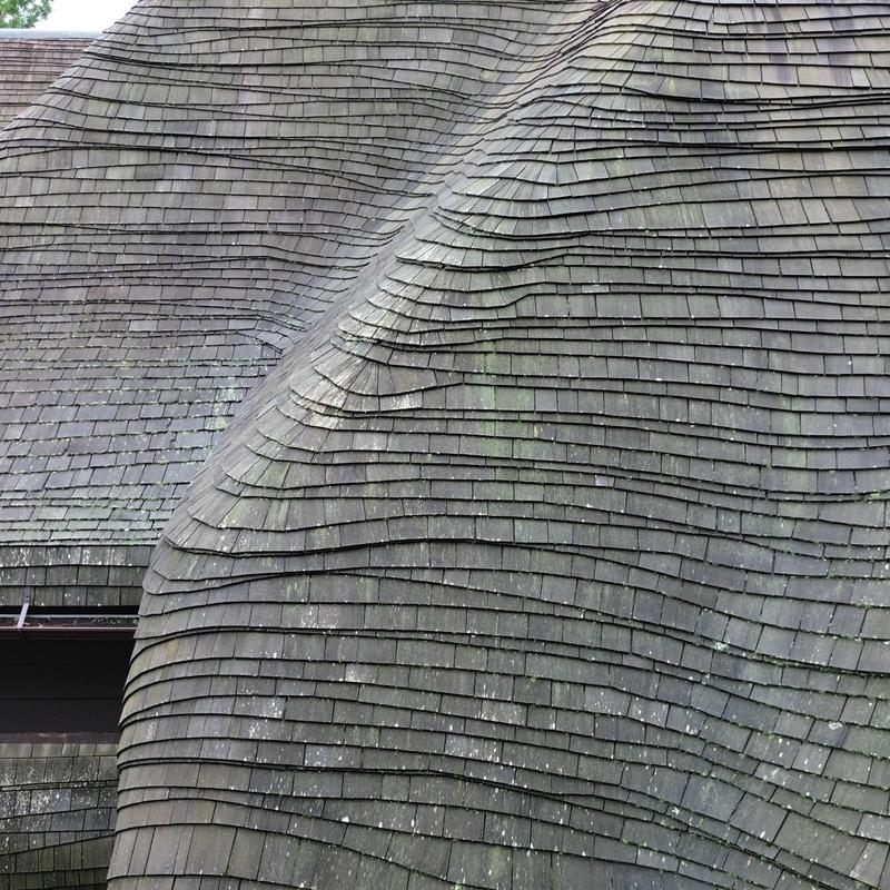Curved cedar shingle roof with rolled eaves detail