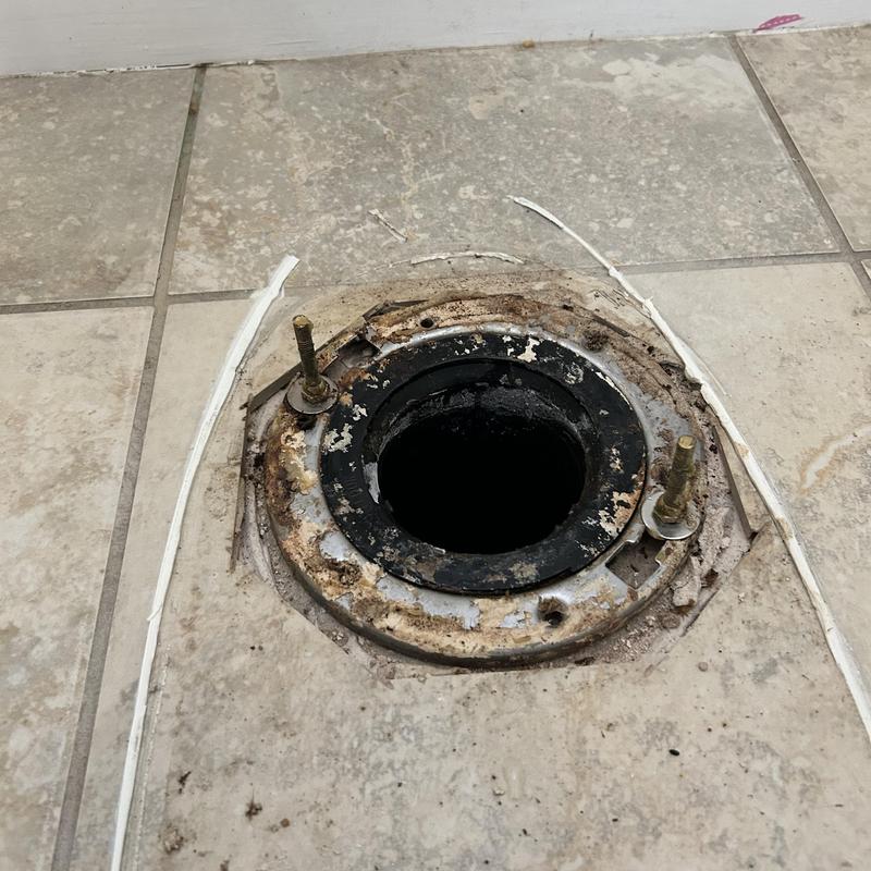 Cast-iron toilet flange set in tiled bathroom floor