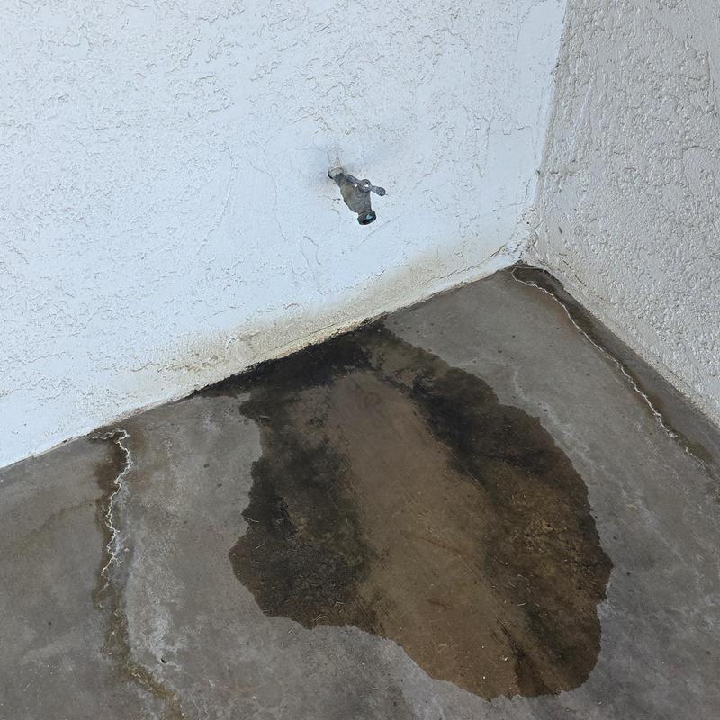 Outdoor hose bib with water leak on concrete floor