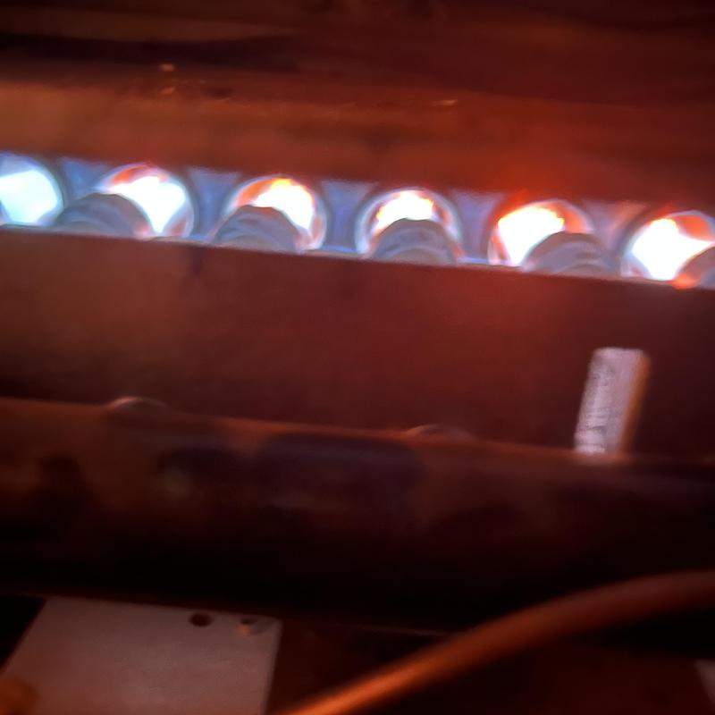 Furnace burner flames during HVAC maintenance check Furnace burner flames during HVAC maintenance check