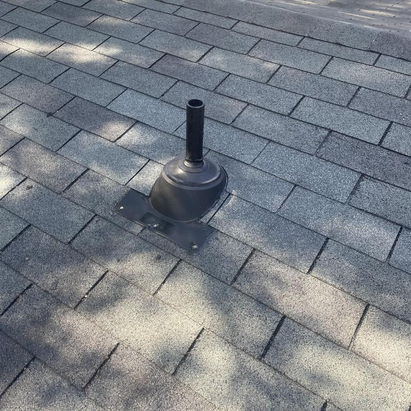 Pipe boot with new shingles on gray roof