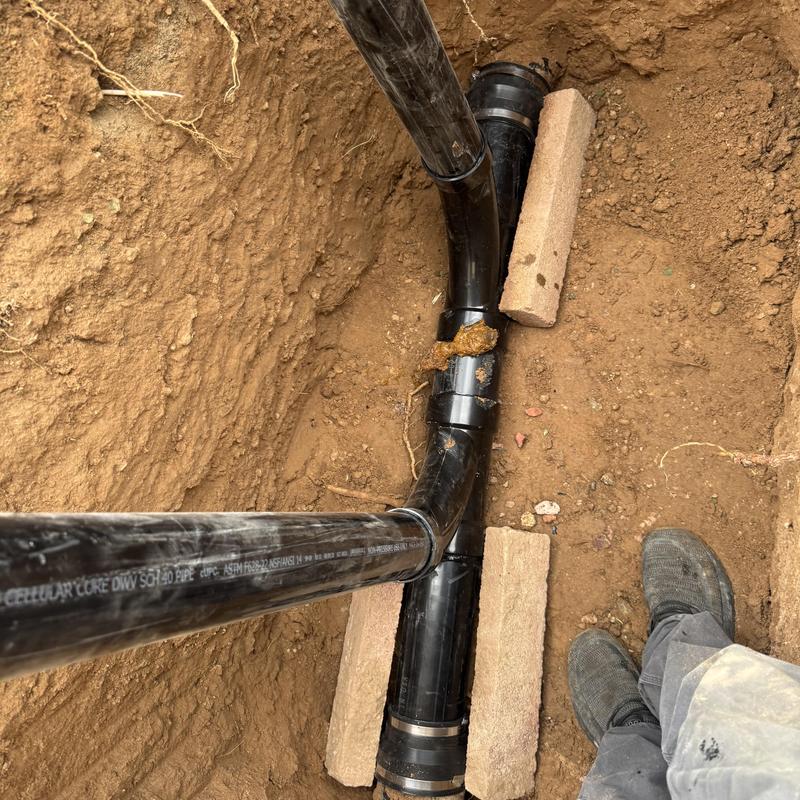 PVC sewer cleanout pipes installation in dirt trench