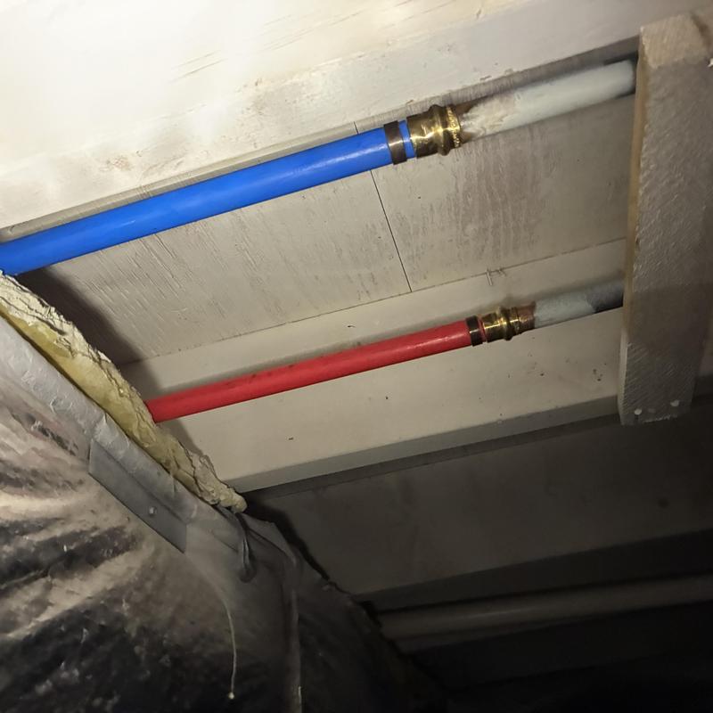 Hot and cold water pipes in crawlspace with fittings