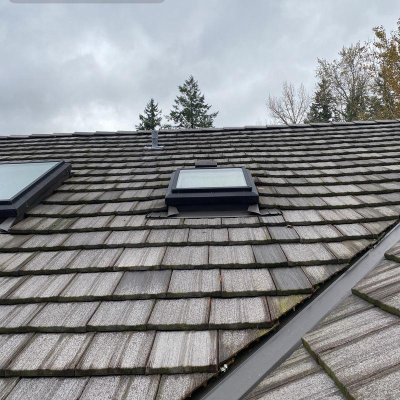 Roof skylight with surrounding wood shingles and flashing