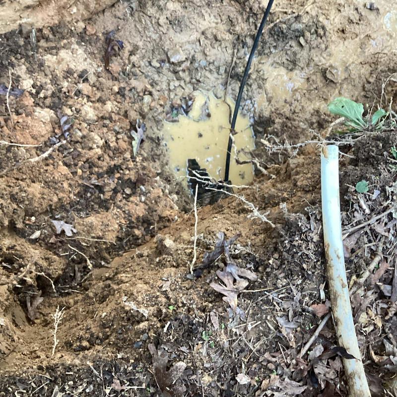 Septic tank discharge line installation in backyard excavation