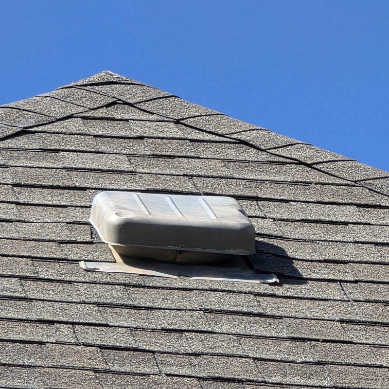 Roof shingles around metal vent on asphalt roof