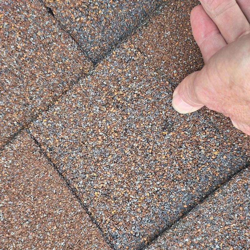 Roof shingles with hail damage close-up inspection