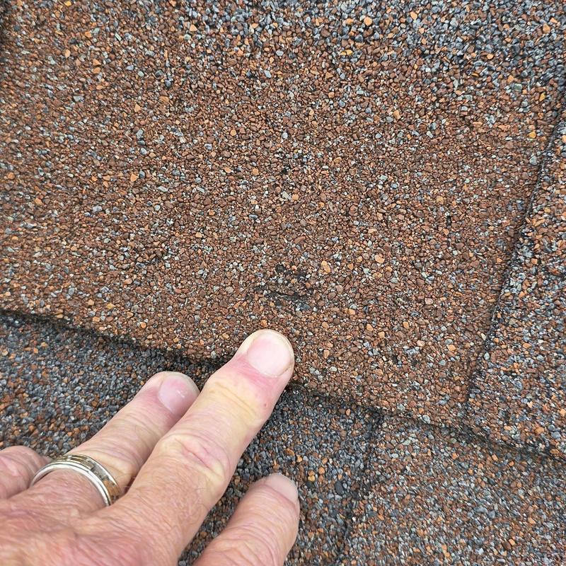 Asphalt roof shingle with hail damage close-up