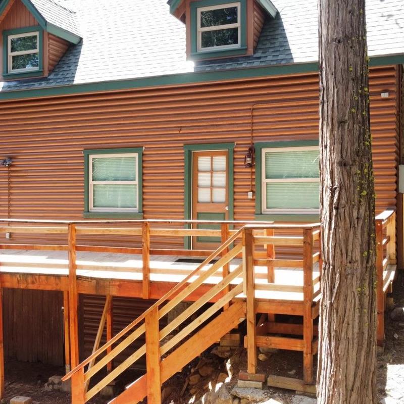 Wooden deck and railing on residential log cabin exterior