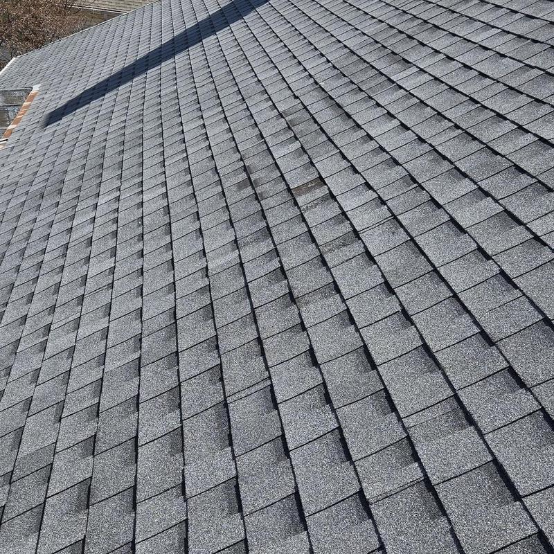 Asphalt shingle roof with visible storm damage spot
