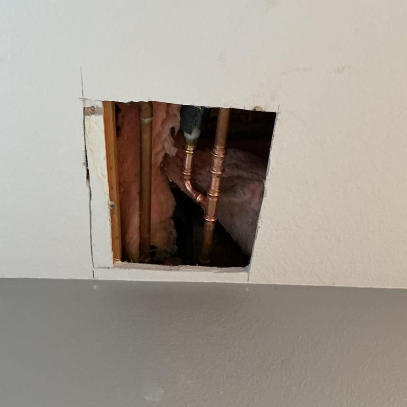 Copper water pipes exposed in ceiling access hole
