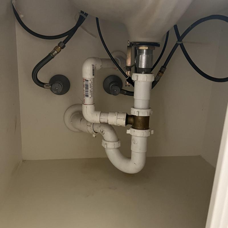 Bathroom sink drain pipes under cabinet with water lines
