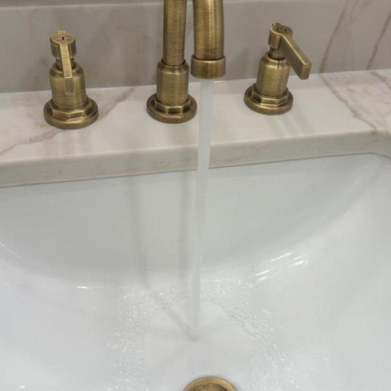 Brushed brass sink faucet with running water