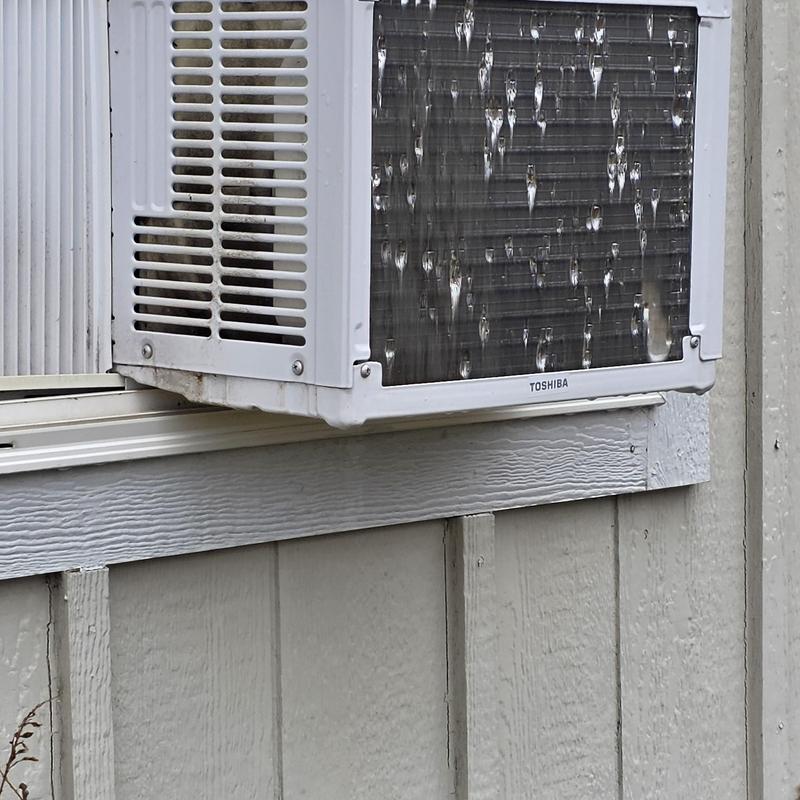 Window air conditioner unit exterior with water droplets