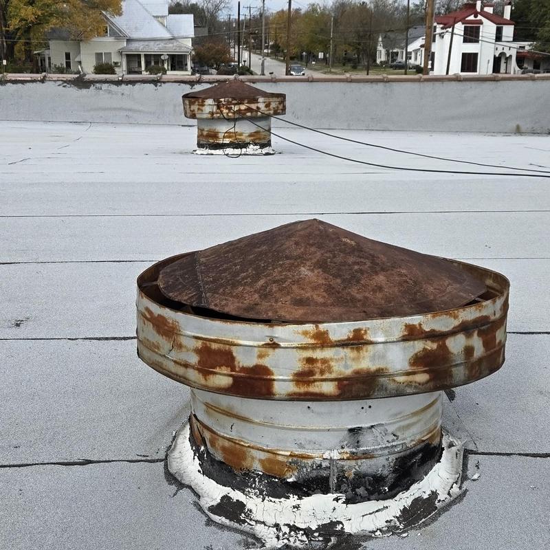 Rusty roof vent pipe caps on flat roof