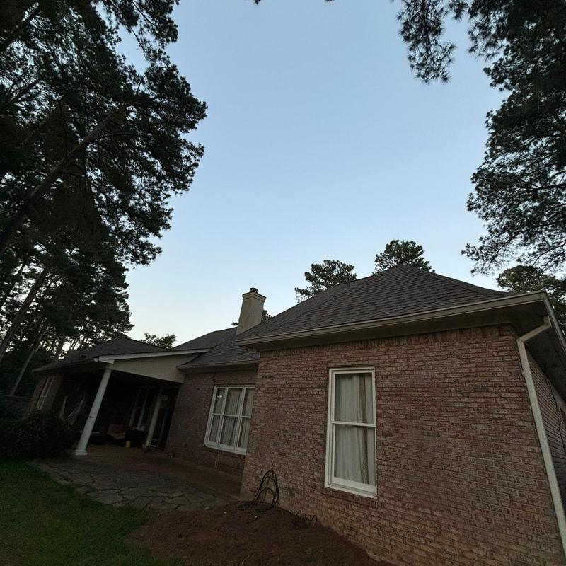 Asphalt shingle roof on brick house during sunset