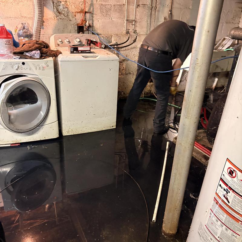 Sewer main pipe with basement flooding and technician