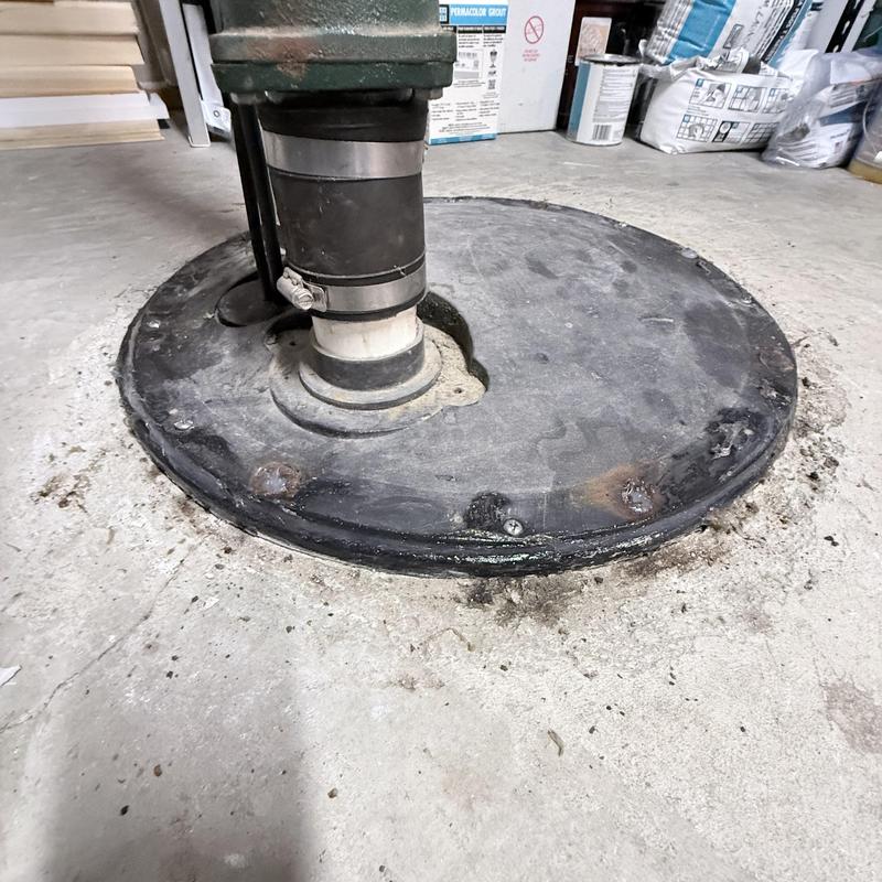 Ejector pit cover and piping in basement floor