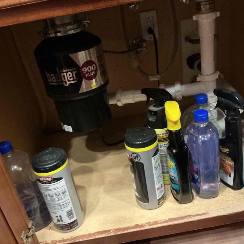 Garbage disposal unit with cleaning products under sink