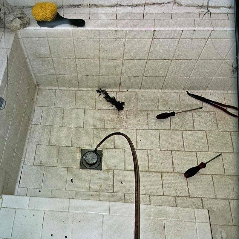 Shower drain line with clog removal tools