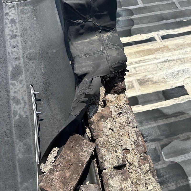 Commercial roof flashing with damaged seal and deteriorated bricks