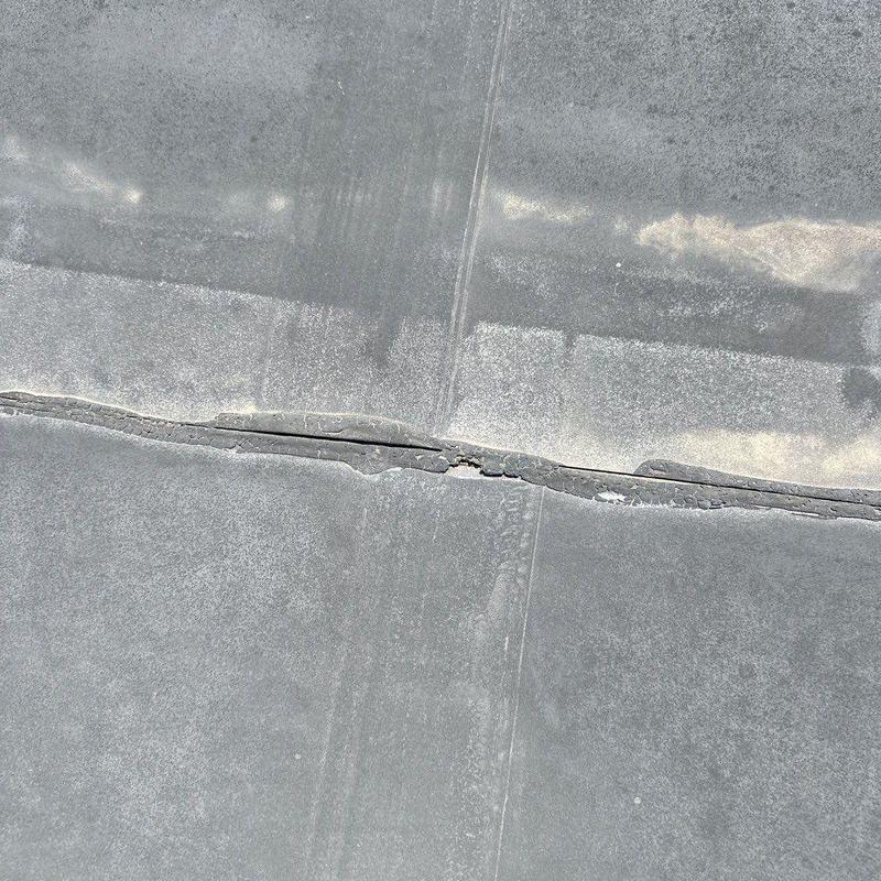 Commercial roof seam with visible cracking and damage