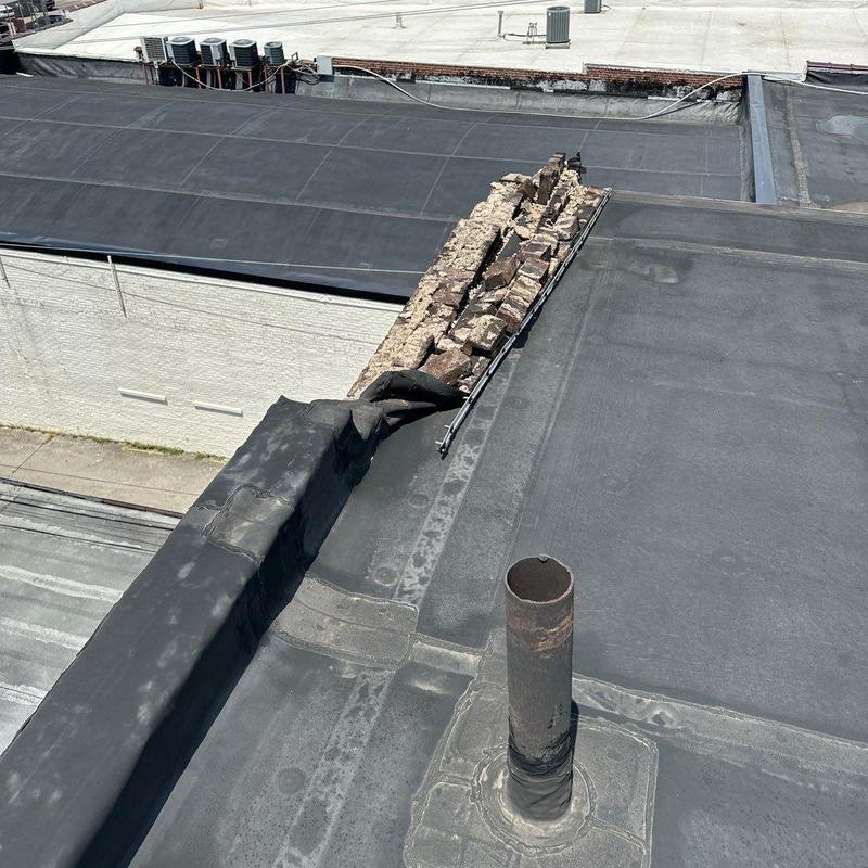 Flat commercial roof membrane with damaged brick parapet wall