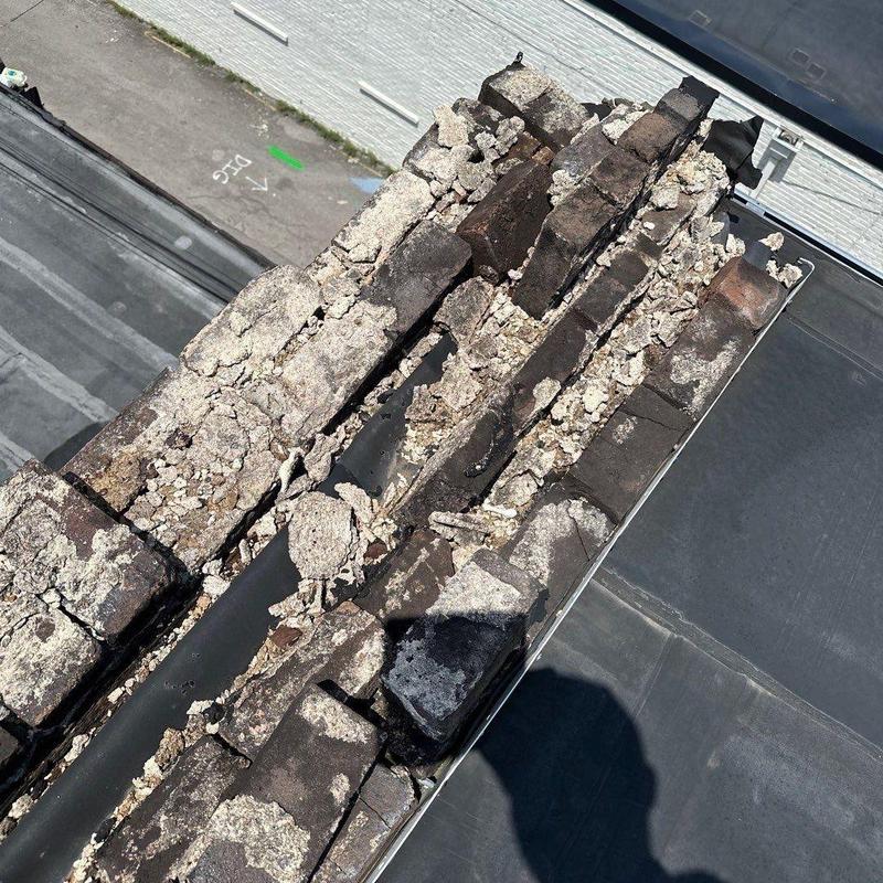 Aged deteriorated chimney crown on commercial roof