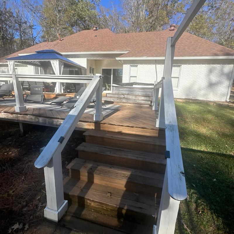 Wooden deck stairs with white railing outdoors