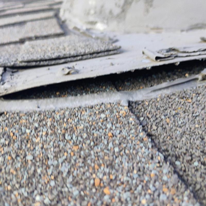 Roof shingles with lifted and damaged edges from hail
