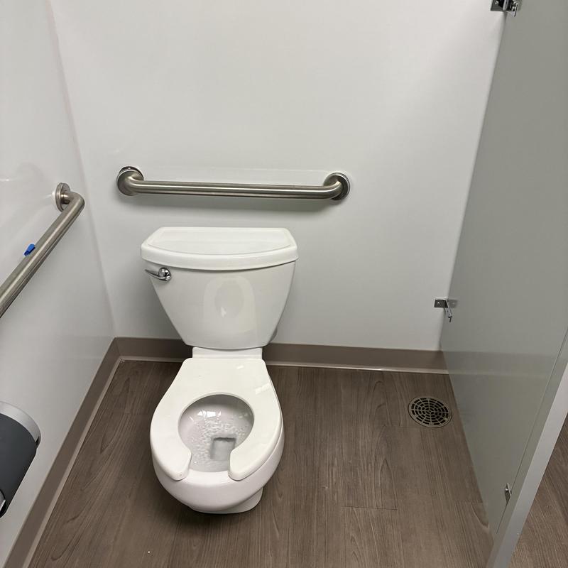 Youth sized toilet with stainless steel handrails