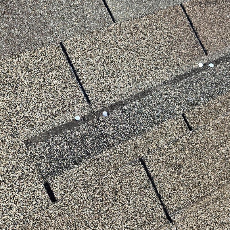 Asphalt shingle roof with exposed nail heads