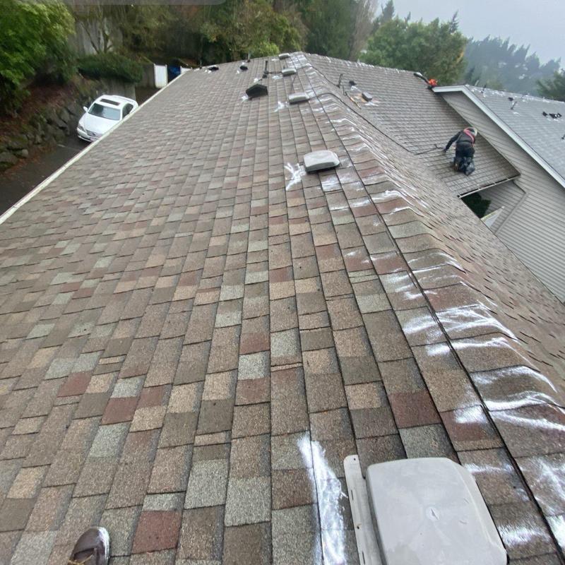 Asphalt shingle roof with markings and roof worker