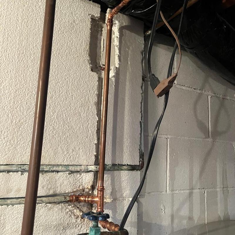 Copper water piping with new fittings in basement wall