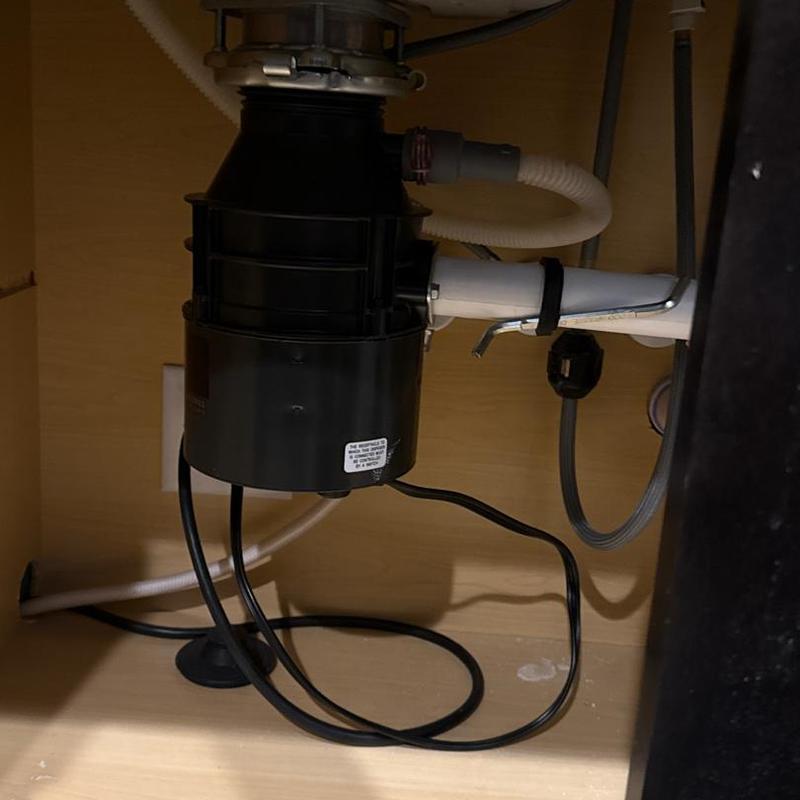Garbage disposal unit with plumbing connections under sink