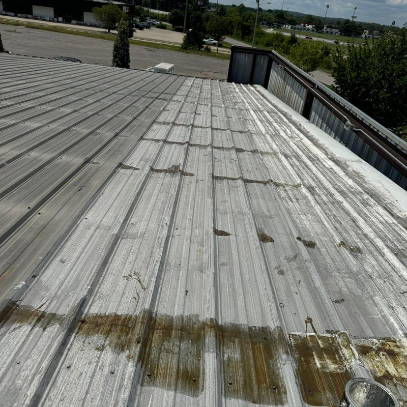 Metal commercial roof showing rust and wear damage
