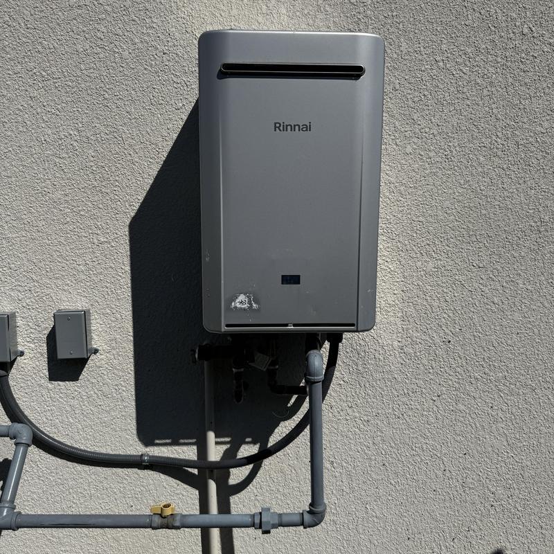 Tankless water heater with gas and water piping