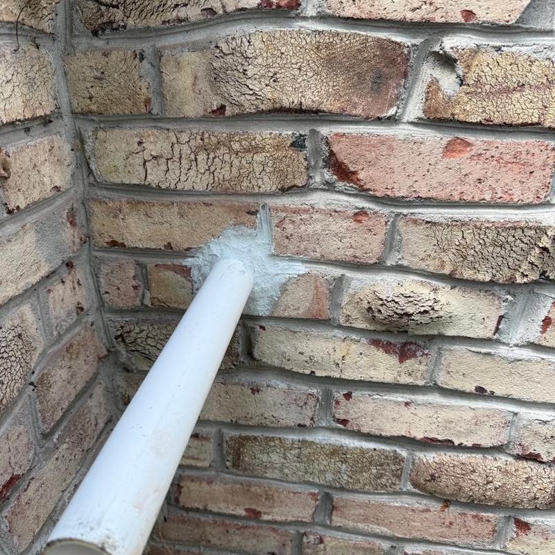PVC pipe sealed into brick wall gap
