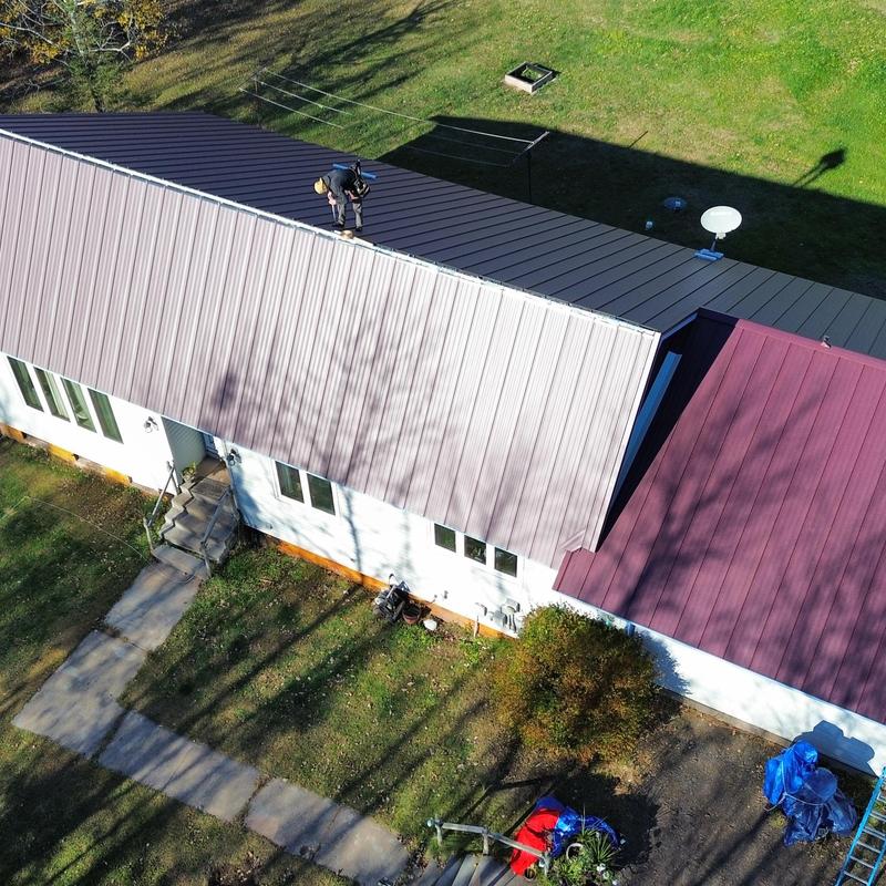 Standing seam steel roof with worker inspecting Standing seam steel roof with worker inspecting