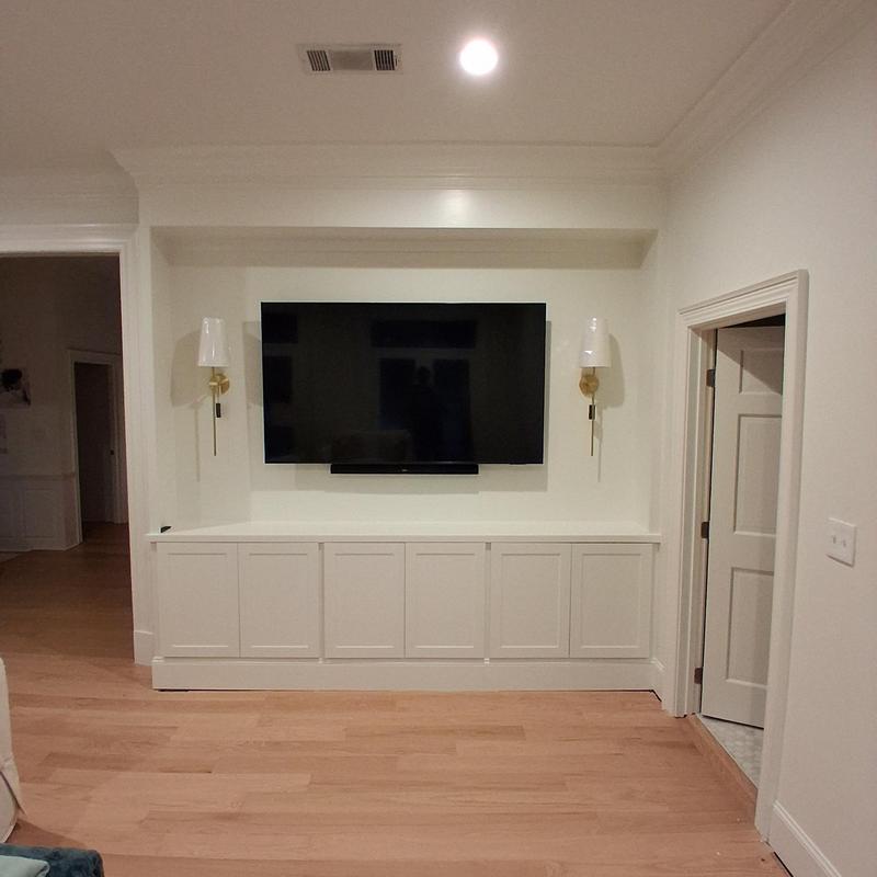 Built-in cabinets with crown mold, sconces, and TV mount Built-in cabinets with crown mold, sconces, and TV mount