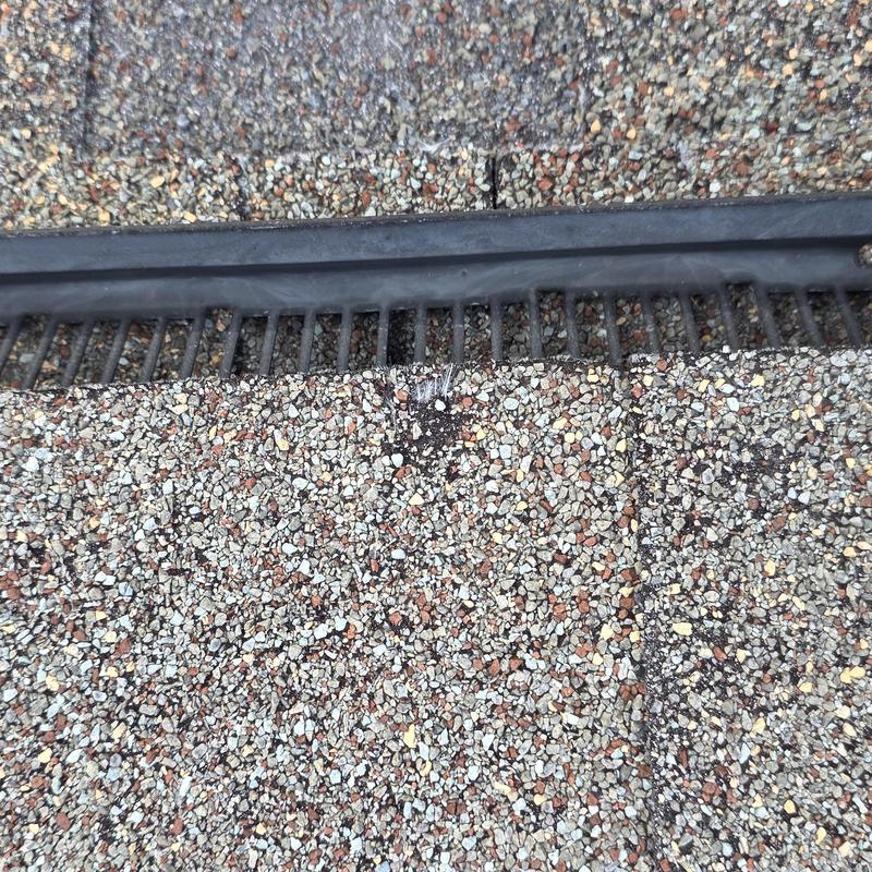 Roof shingles with hail damage near roof vent strip