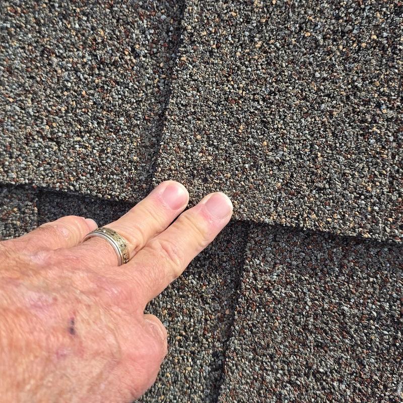 Asphalt roof shingles with hail damage close-up