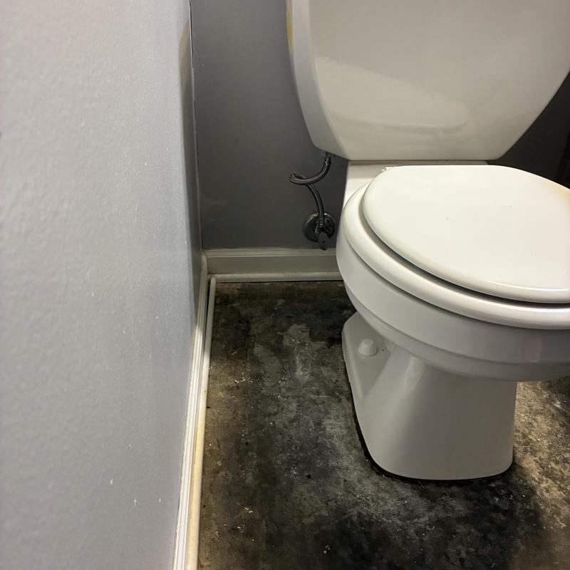 Toilet with new wax ring installation in bathroom corner