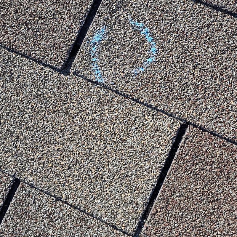 Asphalt shingle roof with storm damage marking