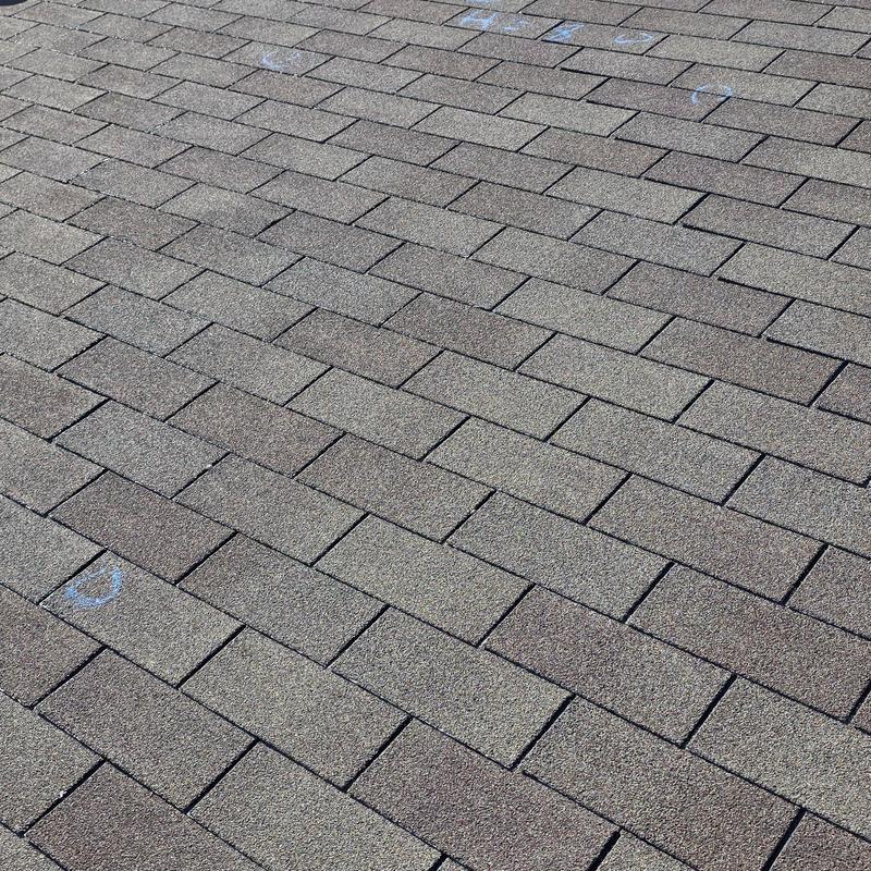 Roof shingles with hail damage markings on surface