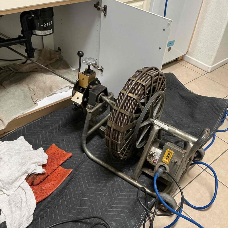 Kitchen sink drain with rooter machine clearing blockage