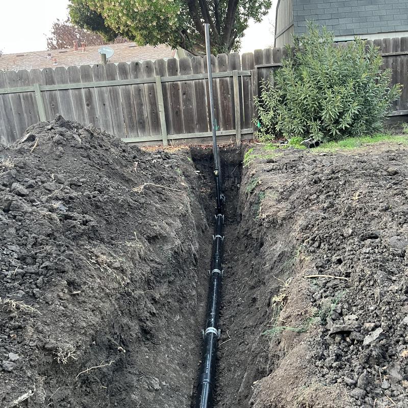 4-inch ABS sewer main trench installation in backyard