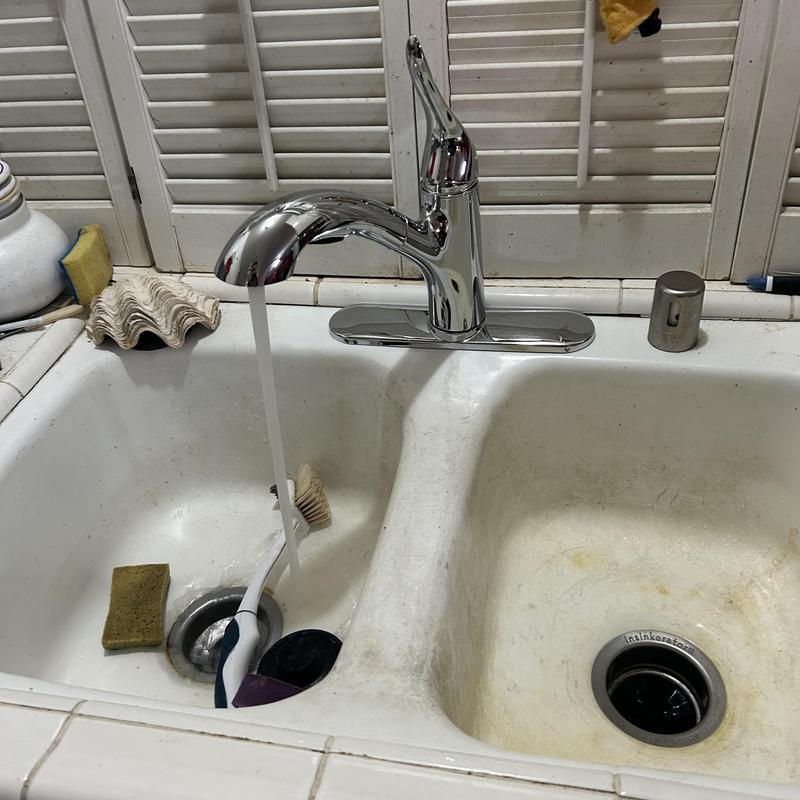 Kitchen sink faucet with running water and sponge