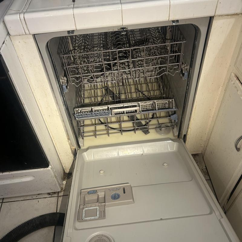Dishwasher installation with open door and racks