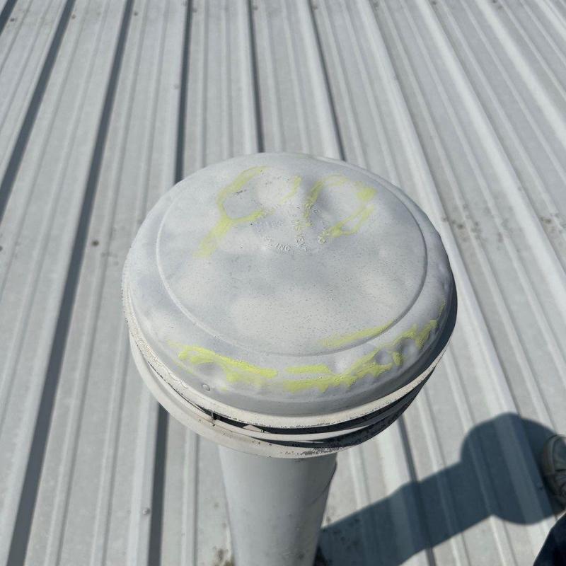 Metal roof vent cap with yellow paint markings